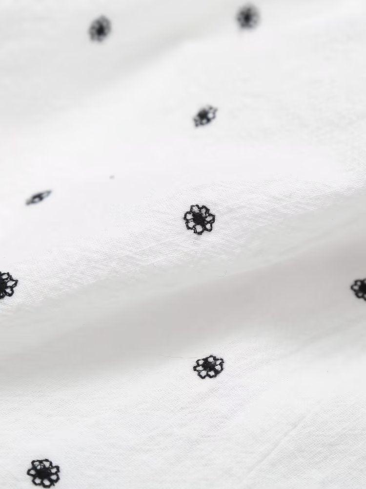 A-line floral pattern embroidered skirt with black floral details on white polyester fabric.
