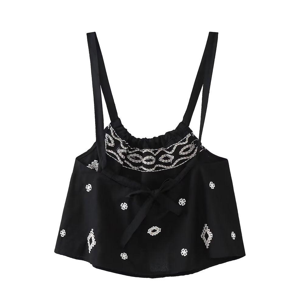 Spaghetti strap loose bow top with embroidered details in black.