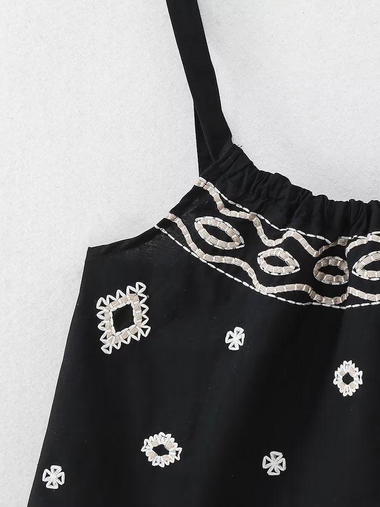Boho vacation style black cami with spaghetti straps and embroidery.