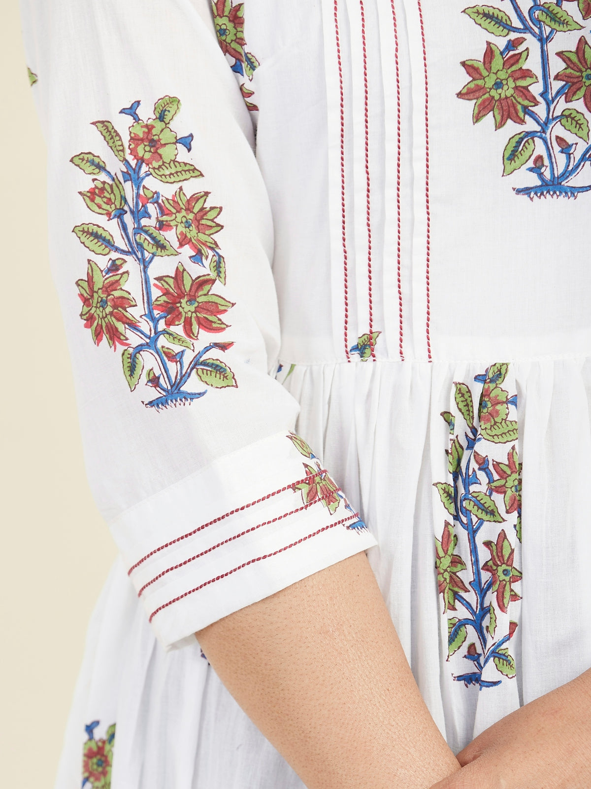 a woman wearing a white dress with a floral design