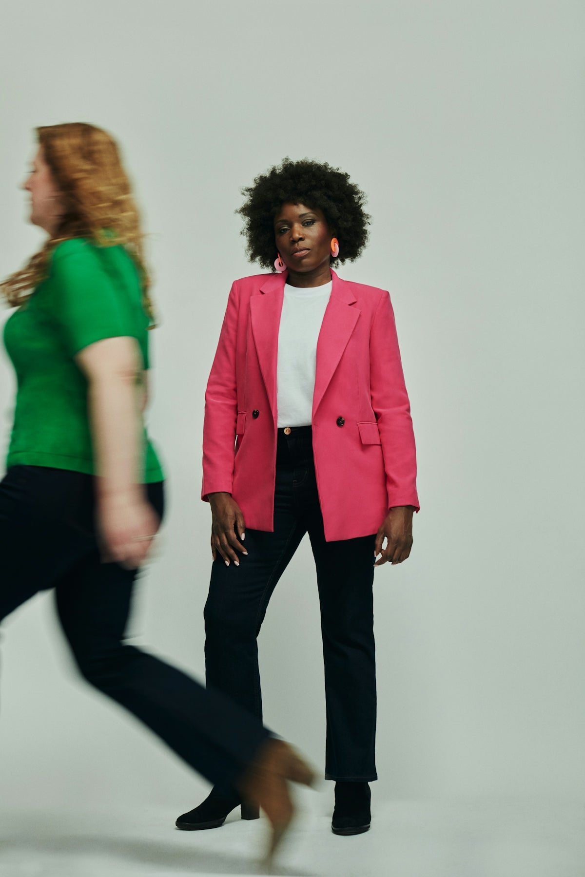 a woman in a pink blazer and black pants