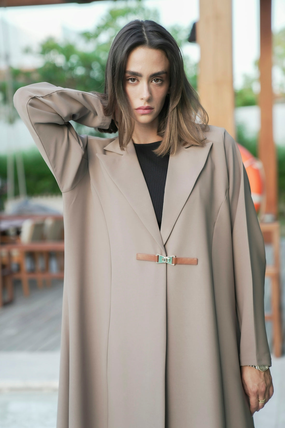 A woman standing in a room with a coat over her head