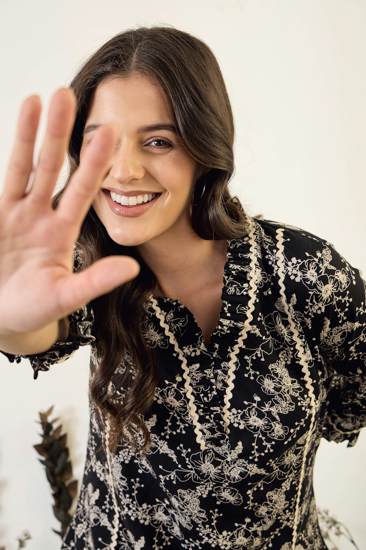 Smiling woman with hand held up