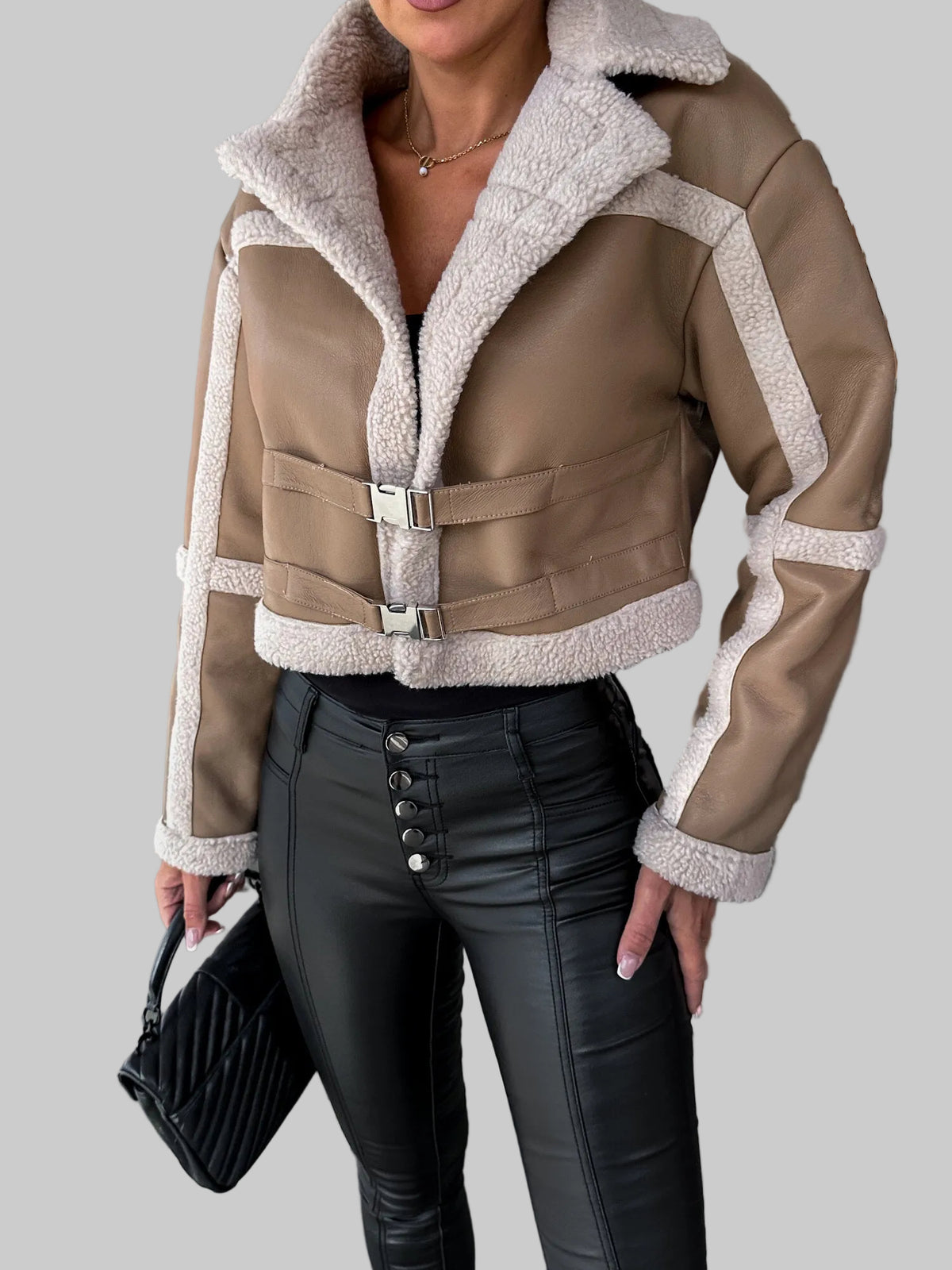 Person wearing a brown leather jacket with white fur lining in an indoor setting.