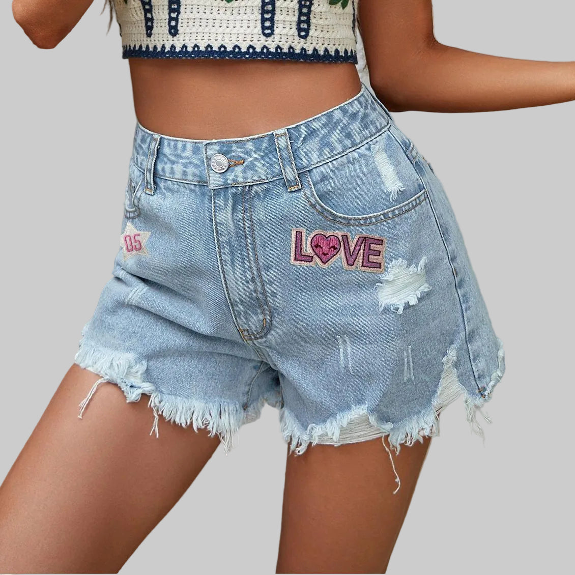 Denim shorts with 'LOVE' embroidery on a neutral background