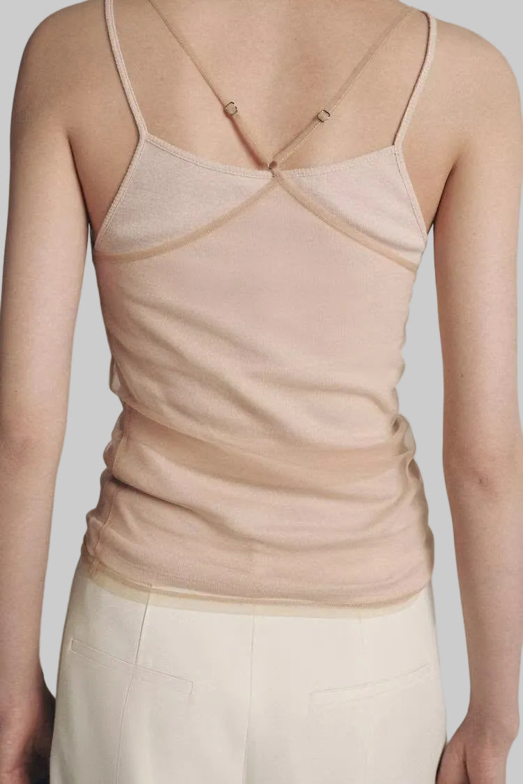 Beige tank top worn by a person on a plain background