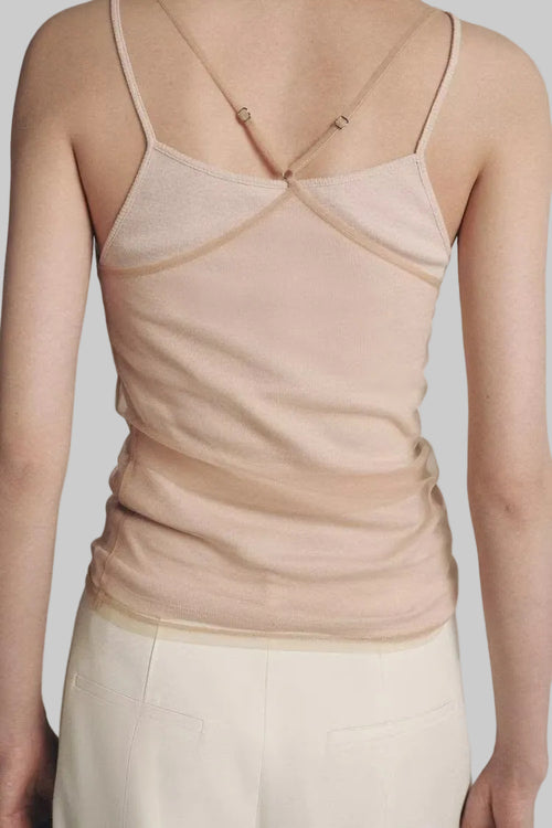 Beige tank top worn by a person on a plain background