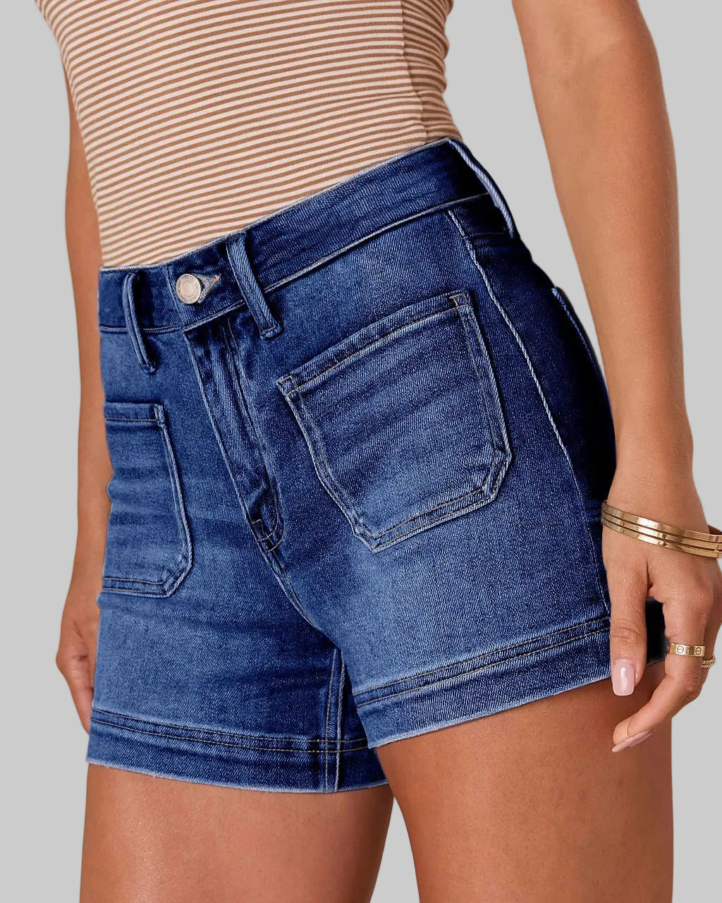 Blue denim shorts worn by a person on a beige background