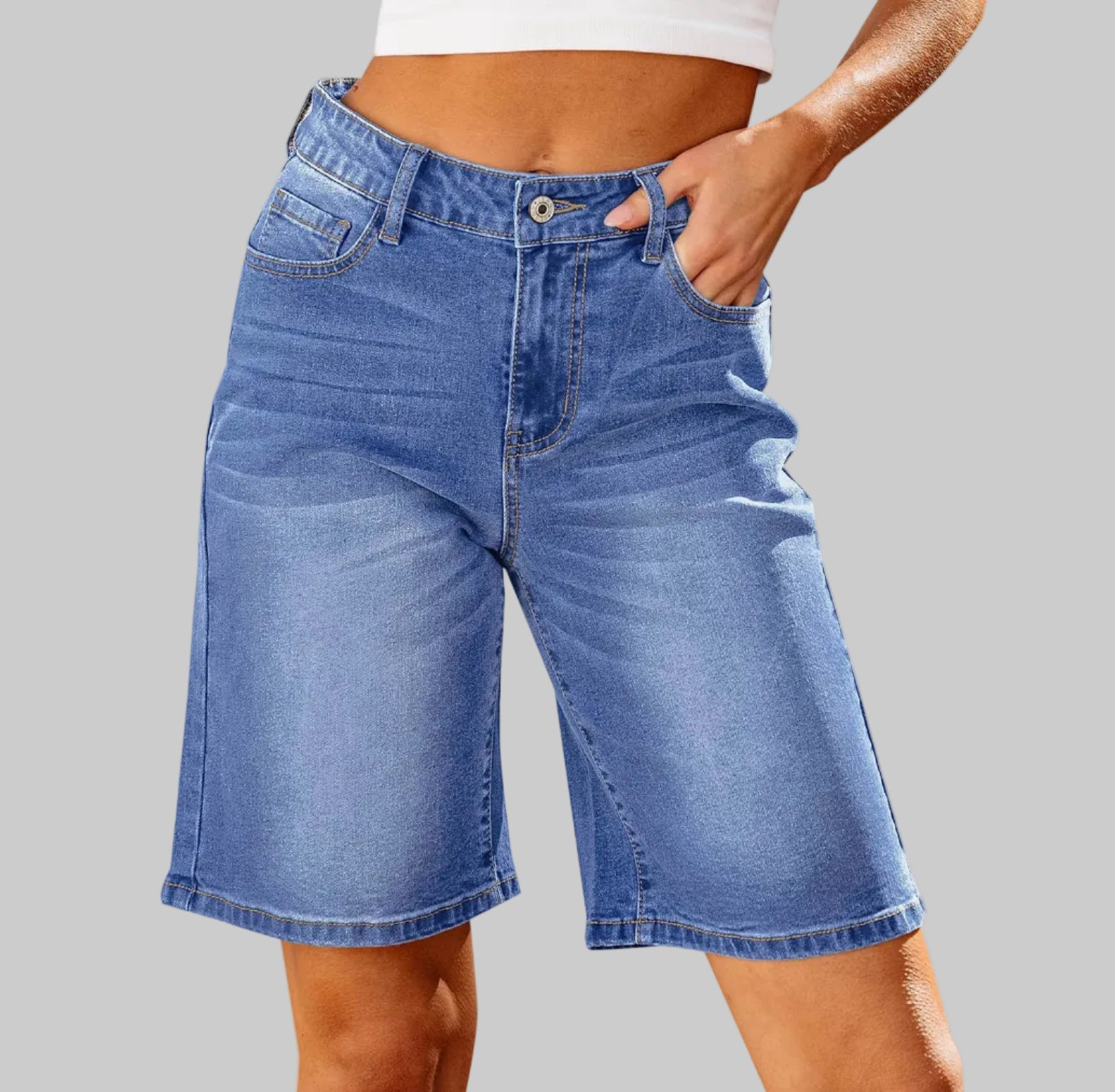 Blue denim shorts worn by a person on a white background