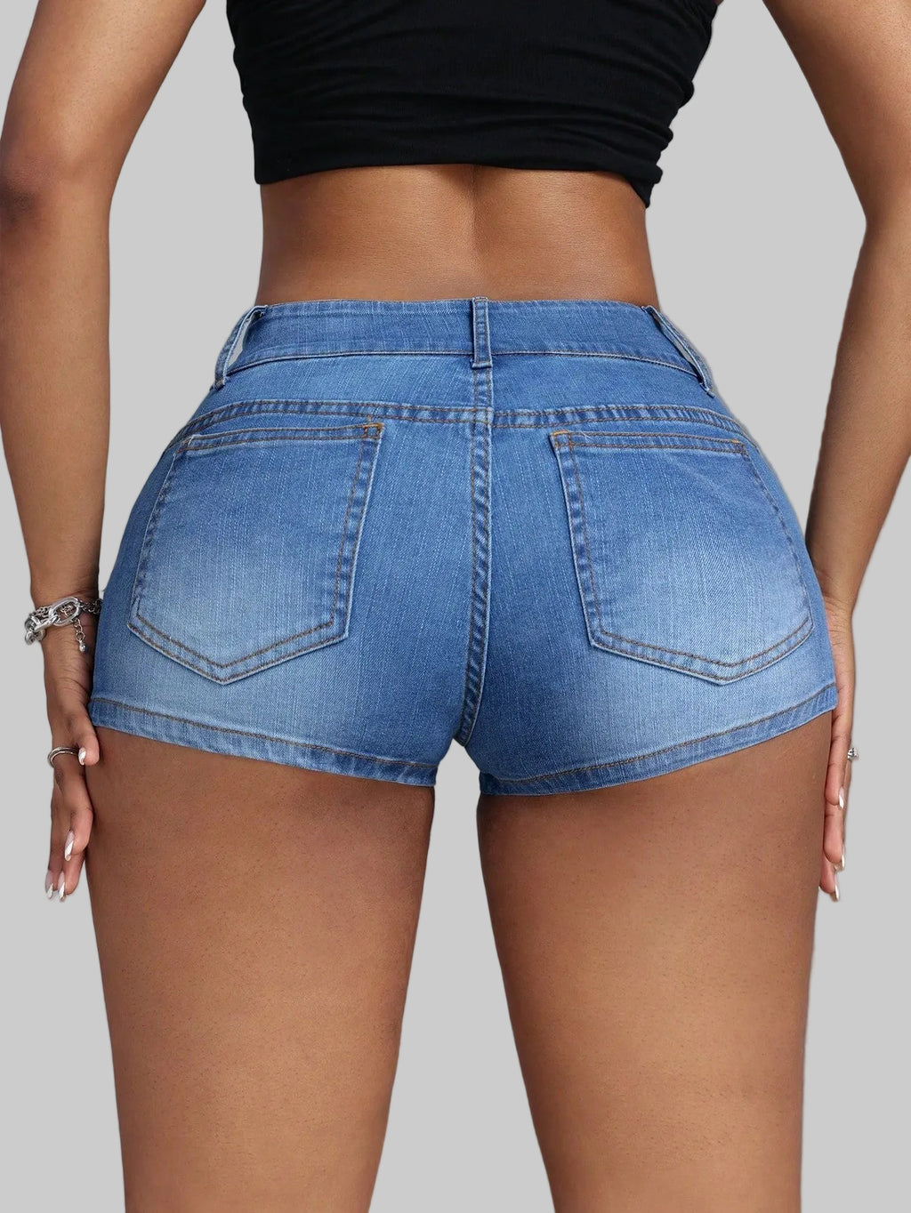 Person wearing blue denim shorts on a gray background