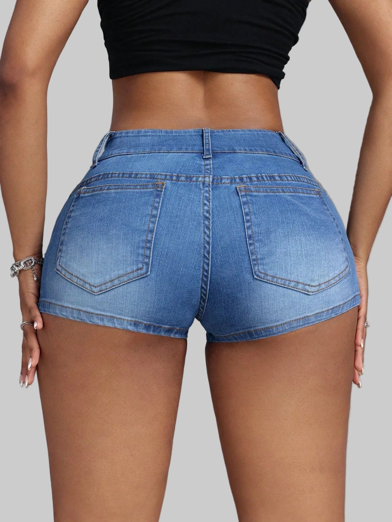 Person wearing blue denim shorts on a gray background