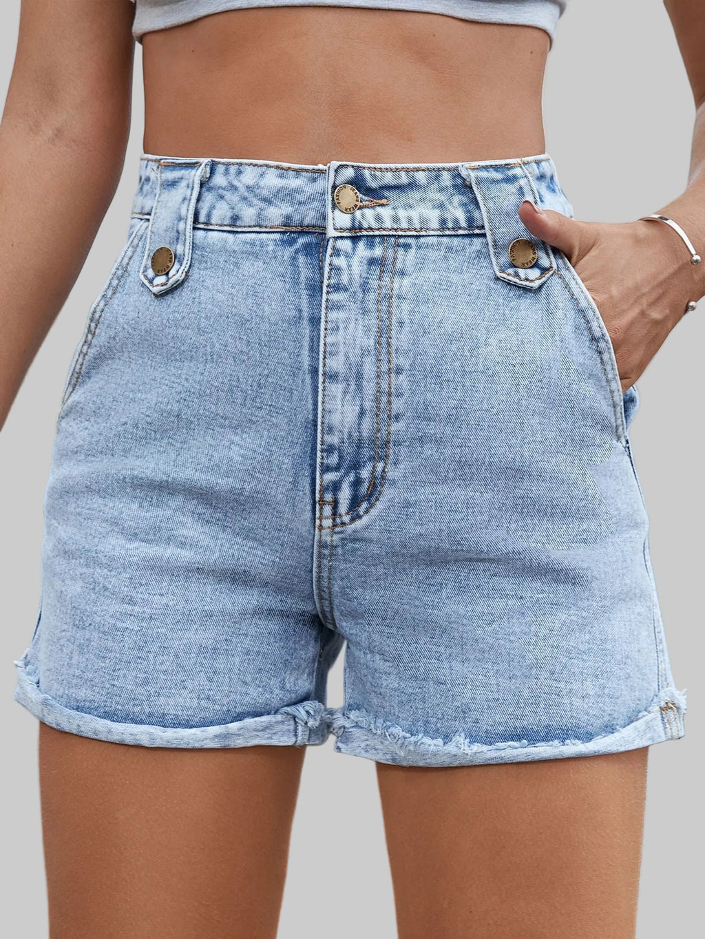Person wearing light blue denim shorts with a blurred background