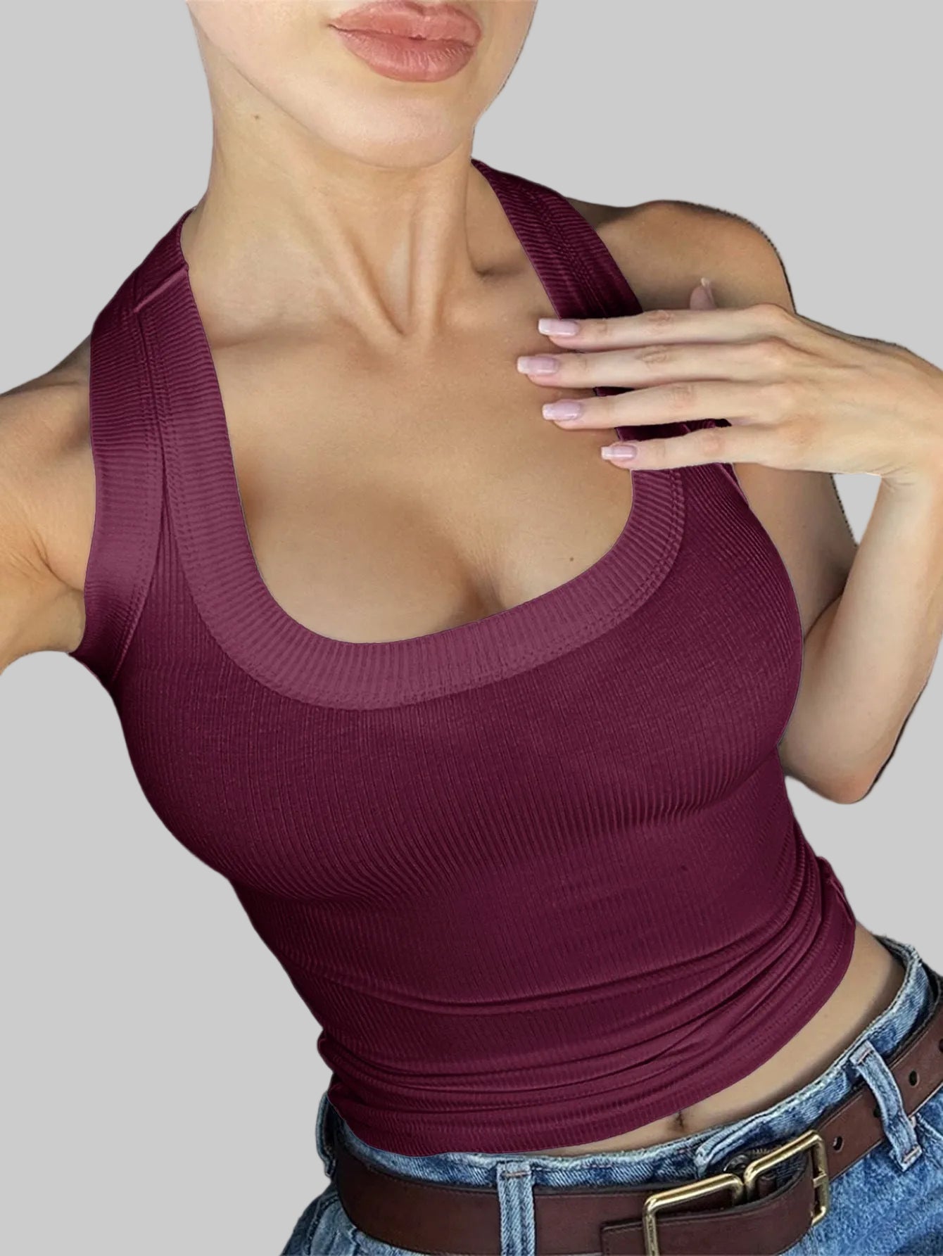 Person wearing a maroon tank top sitting in a car.
