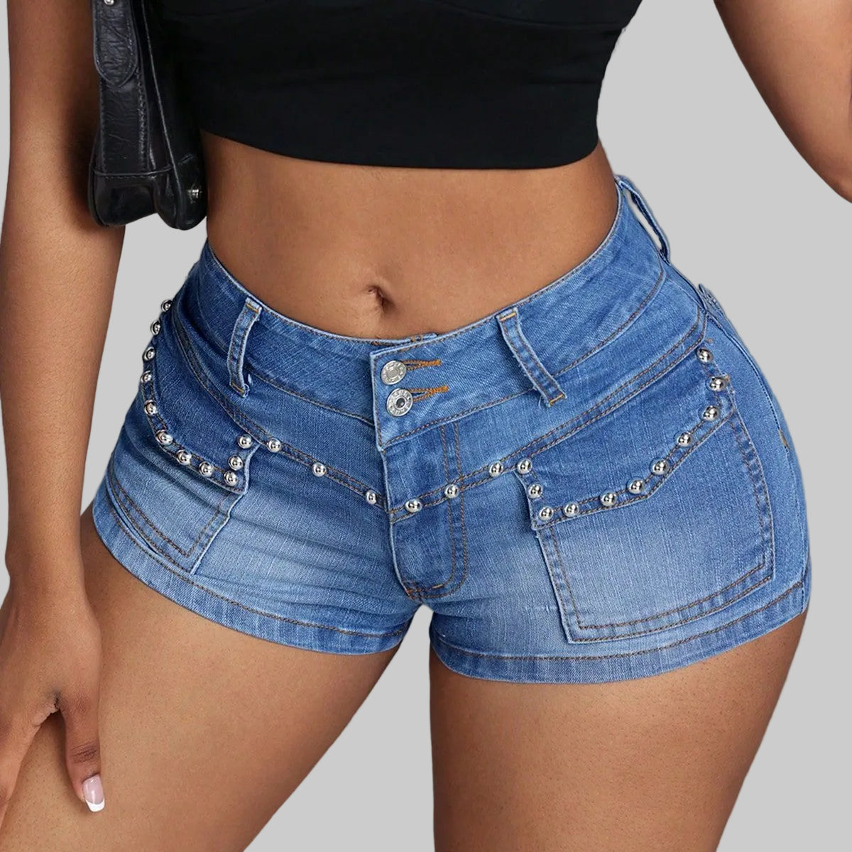 Blue denim shorts with embellishments on a plain background