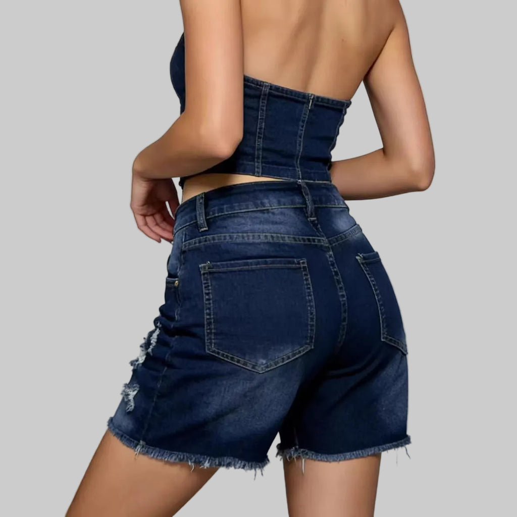 Person wearing blue denim shorts on a plain background