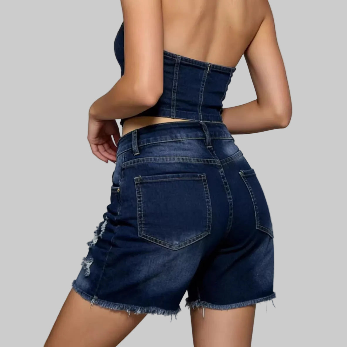 Person wearing blue denim shorts on a plain background