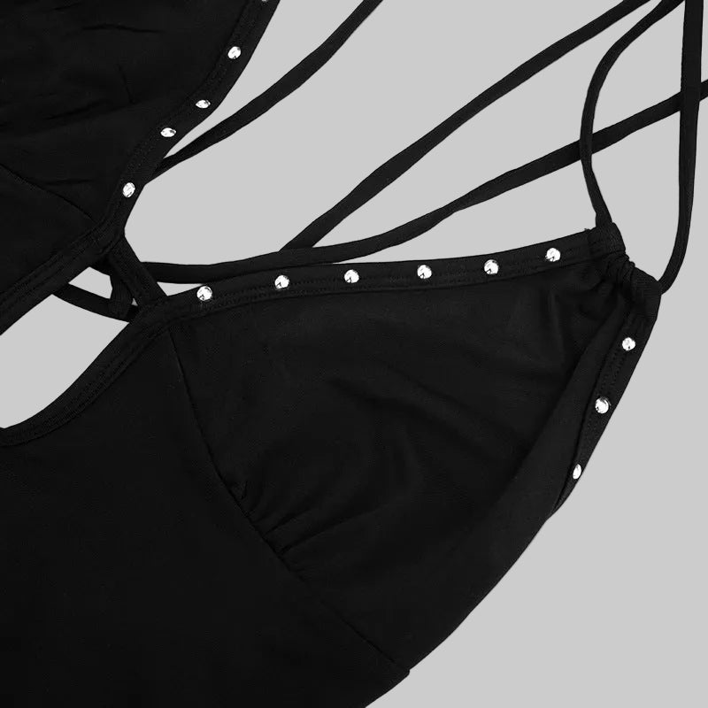 Black swimsuit with thin straps and pearl-like embellishments on a white background