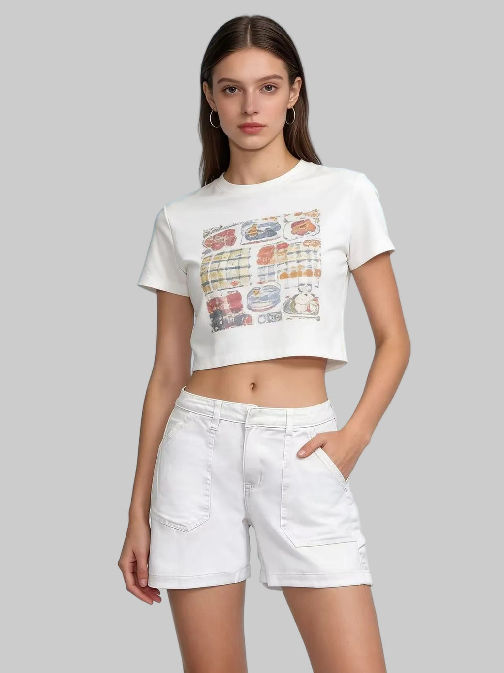 Woman wearing a white graphic t-shirt and shorts against a light blue background