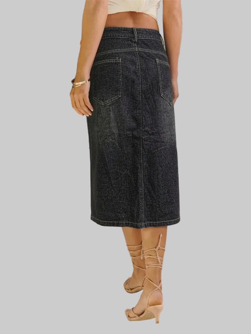 Person wearing a black denim skirt with a blurred background
