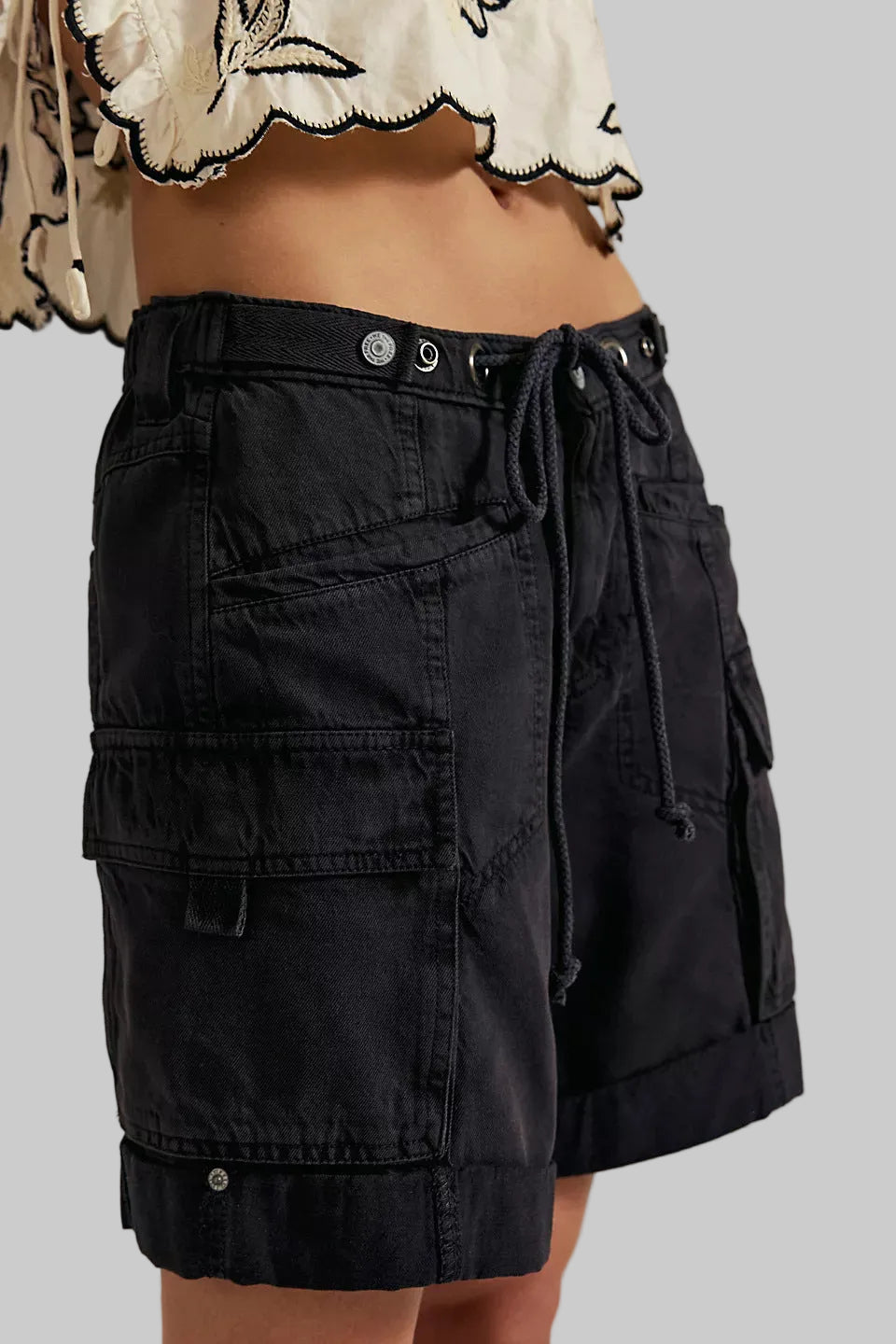Black cargo shorts with a tie waist on a neutral background