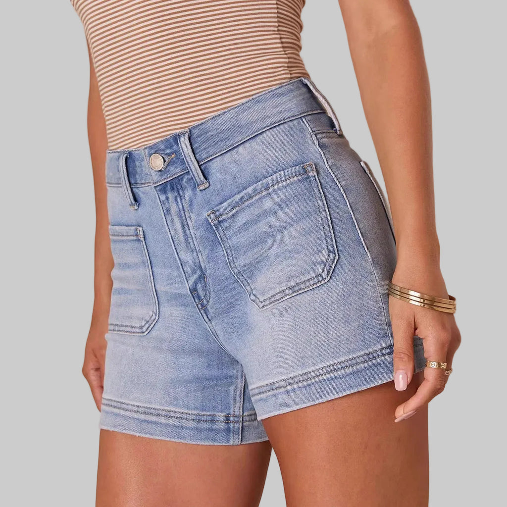 Person wearing light blue denim shorts on a beige background