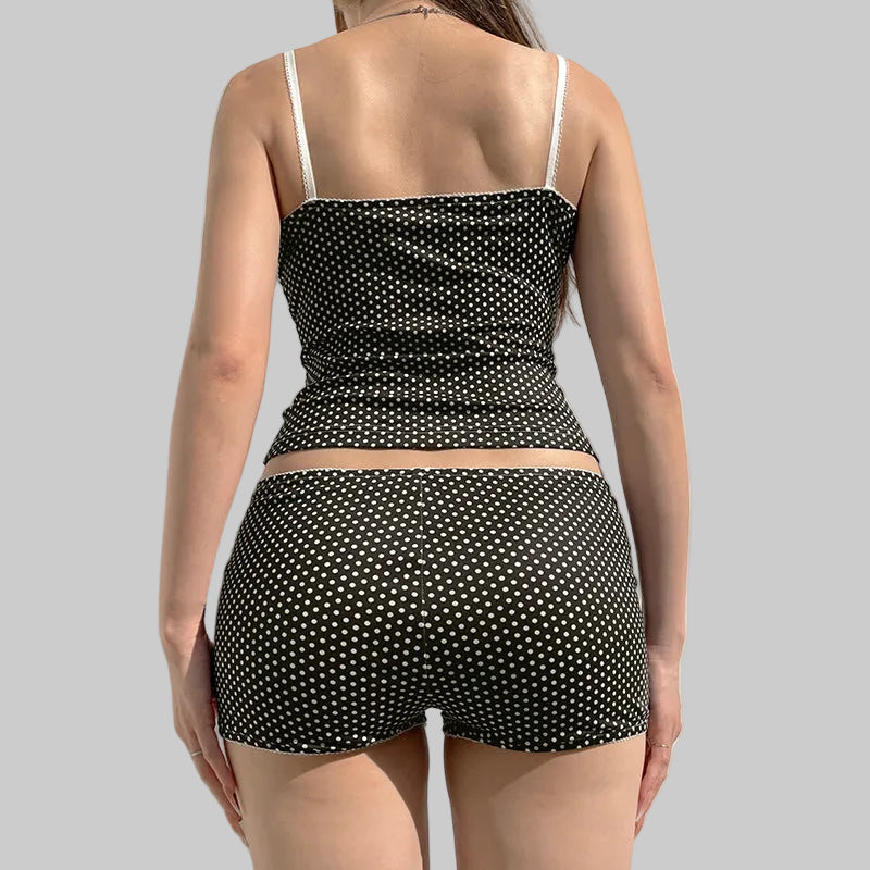 Person wearing a black polka dot two-piece swimsuit against a neutral background